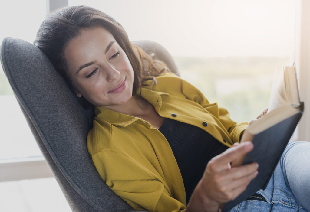 Relaxed woman reading a book at home, symbolizing healing, peace, and recovery through grief counseling in Houston, TX