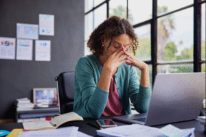 Stressed woman sitting at desk needing stress management in Houston