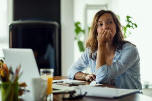 Stressed woman sitting at desk needing stress management in Houston