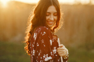 Christian woman smiling outdoors while holding a Bible and notebook, symbolizing peace and confidence through faith-based counseling in Frisco, Texas.