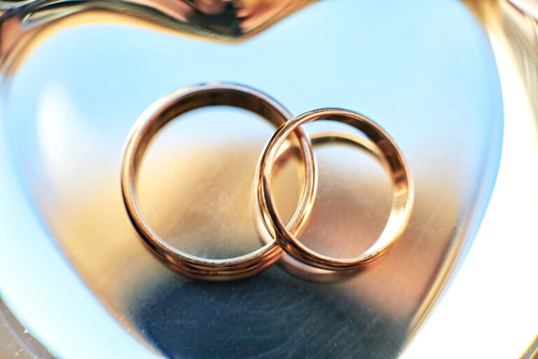 Two wedding rings on a wooden surface representing marriage struggles in Christian couples counseling Frisco TX