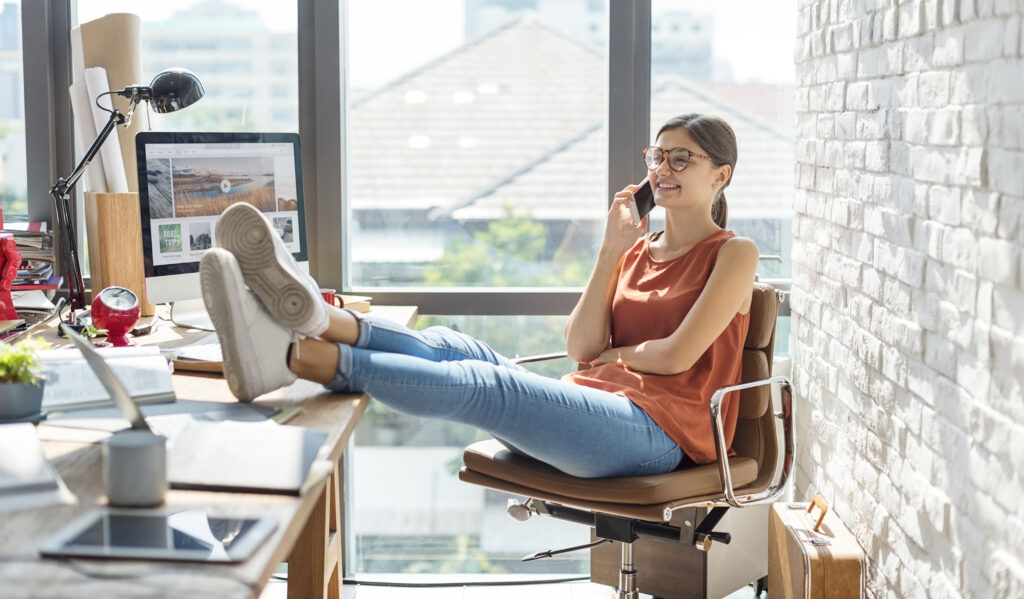 Woman sitting at desk looking thoughtful, imposter syndrome counseling for high-achieving women Frisco TX